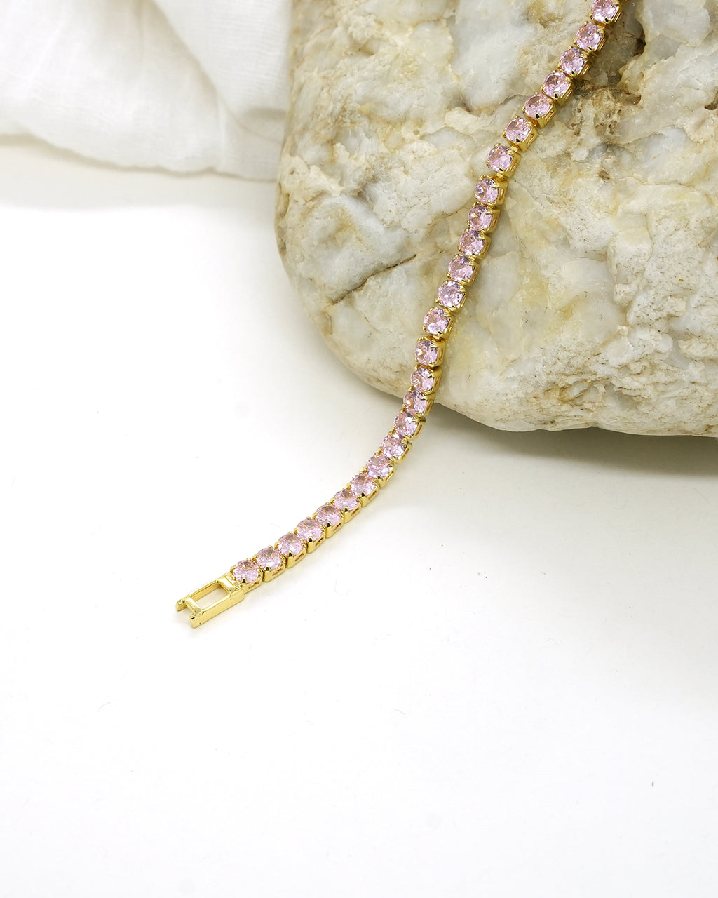 A timeless gold-plated tennis bracelet featuring elegant rose-pink stones that add a soft sparkle and luxurious charm to any look