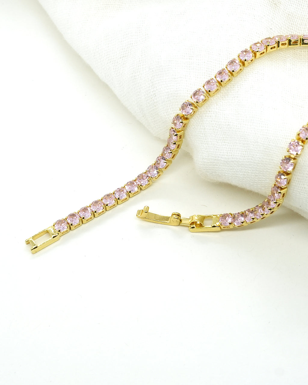A timeless gold-plated tennis bracelet featuring elegant rose-pink stones that add a soft sparkle and luxurious charm to any look
