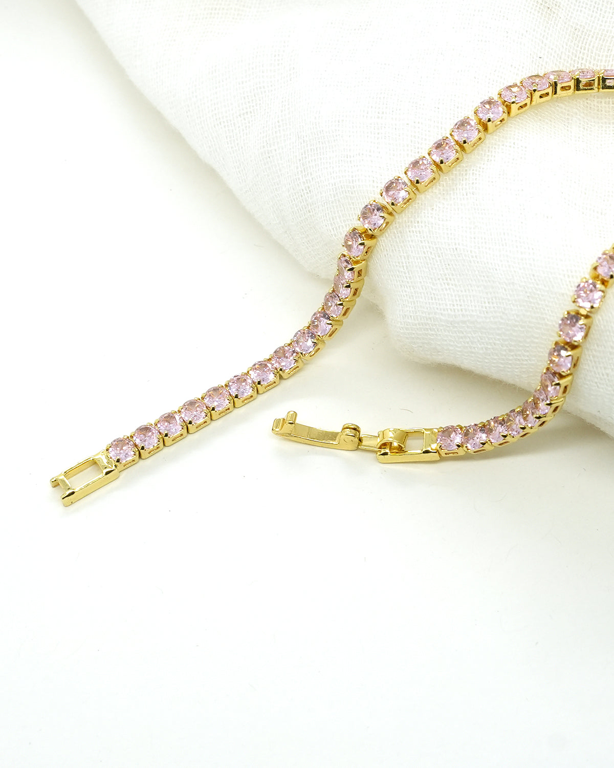 A timeless gold-plated tennis bracelet featuring elegant rose-pink stones that add a soft sparkle and luxurious charm to any look